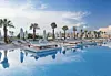 Premium resort pool with palm trees, loungers and blue-sky reflections