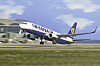 Ett Ryanair-flygplan lyfter från en flygplats med blå himmel i bakgrunden.