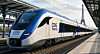 Et hvidt og blåt CDG Express-tog holder ved en overdækket station med Eiffeltårnet i baggrunden.