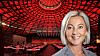 Portrait of Satu Andersson in front of a red-lit auditorium with rows of tables and seats.