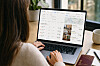 En person sitter vid en bärbar dator som visar sökresultat och resealternativ från Google Flights och Google Hotels.
